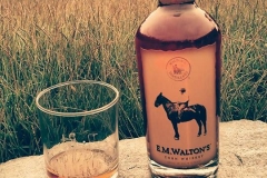 E.M. Walton's Corn Whiskey in a meadow